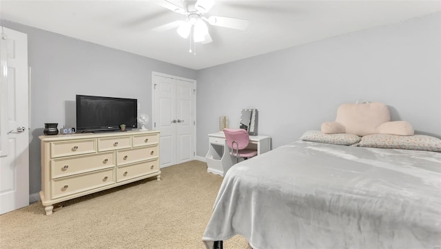 bedroom featuring a closet, baseboards, a ceiling fan, and light carpet