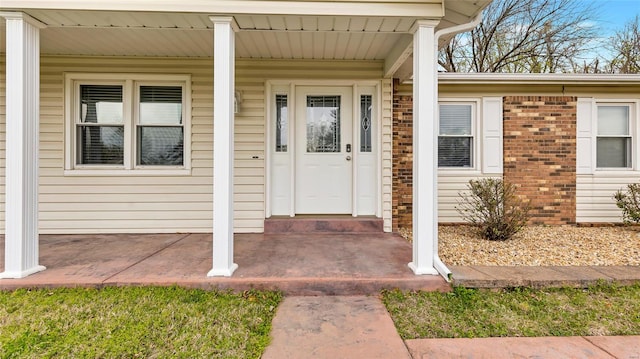 property entrance featuring brick siding