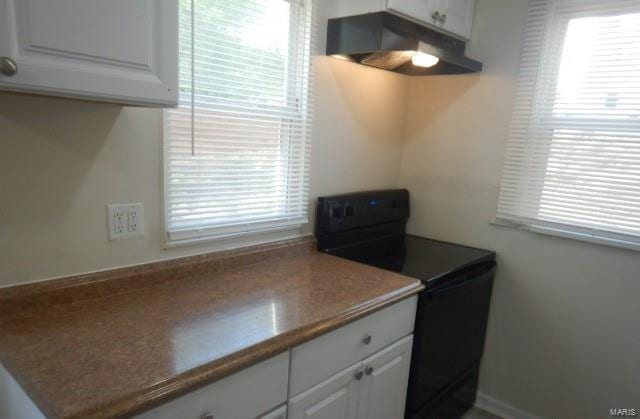 kitchen with under cabinet range hood, white cabinetry, and black / electric stove