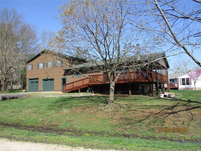 view of front facade with an attached garage, a wooden deck, and a front lawn