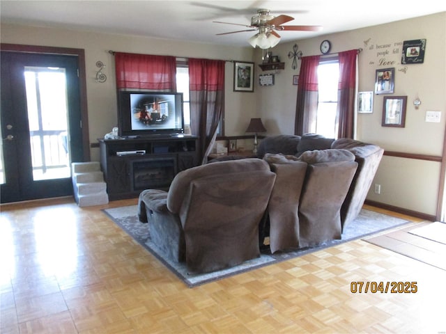 living room featuring ceiling fan and baseboards