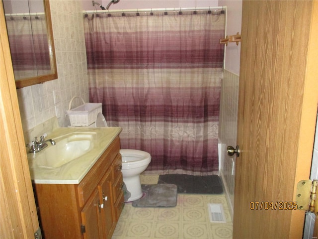 full bath with visible vents, toilet, tile walls, vanity, and tile patterned flooring