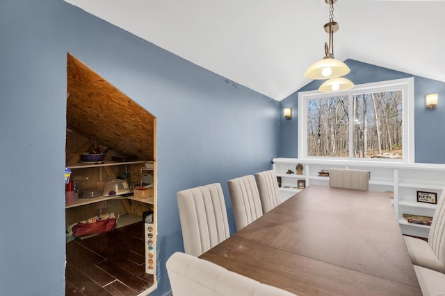 dining space featuring vaulted ceiling and wood finished floors