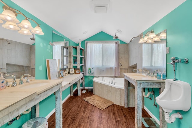 full bathroom with a bath, wood finished floors, a sink, and lofted ceiling