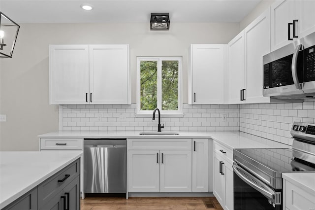 kitchen featuring a sink, backsplash, light countertops, and stainless steel appliances