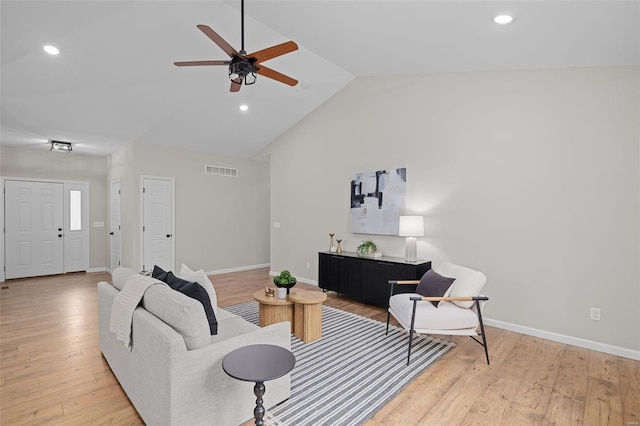 living room with light wood finished floors, vaulted ceiling, a ceiling fan, and visible vents