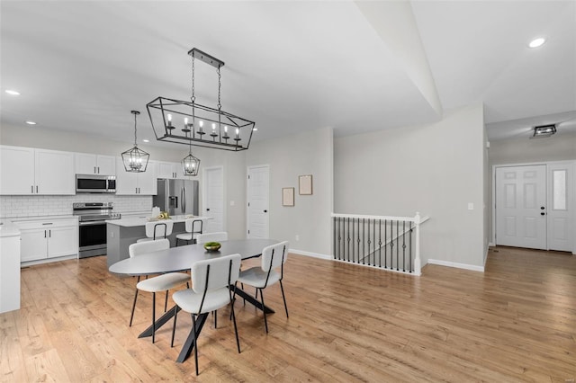 dining space featuring baseboards, recessed lighting, a notable chandelier, and light wood-style floors