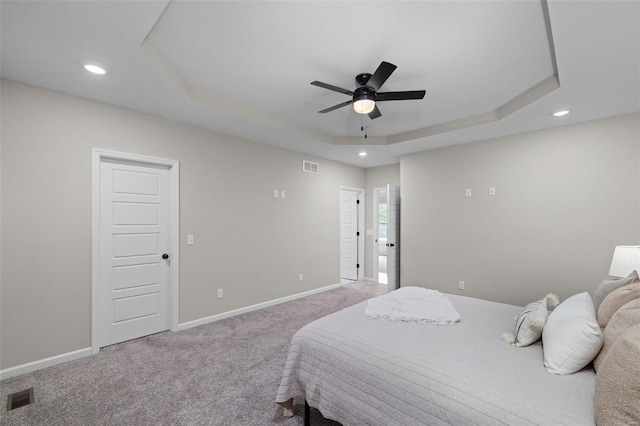 bedroom featuring visible vents, baseboards, a raised ceiling, and carpet