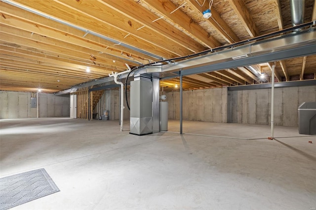 unfinished basement with electric panel, heating unit, and gas water heater