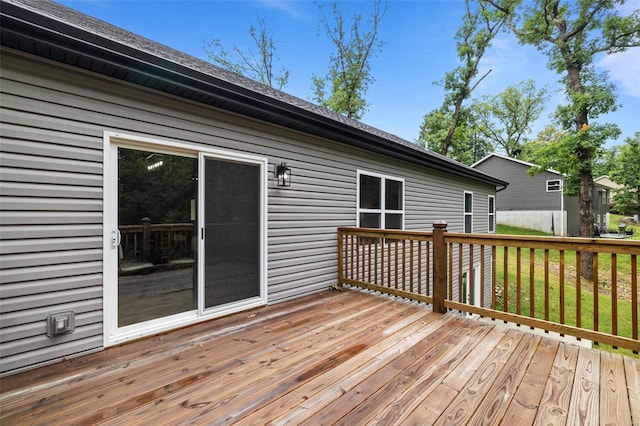 wooden terrace featuring a lawn