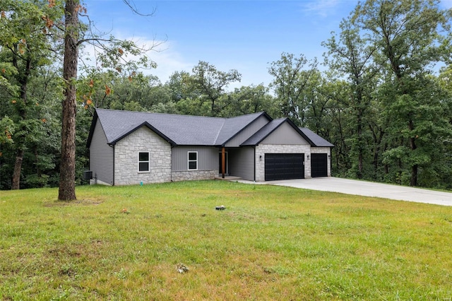 view of front of property featuring concrete driveway, stone siding, an attached garage, a front yard, and a shingled roof