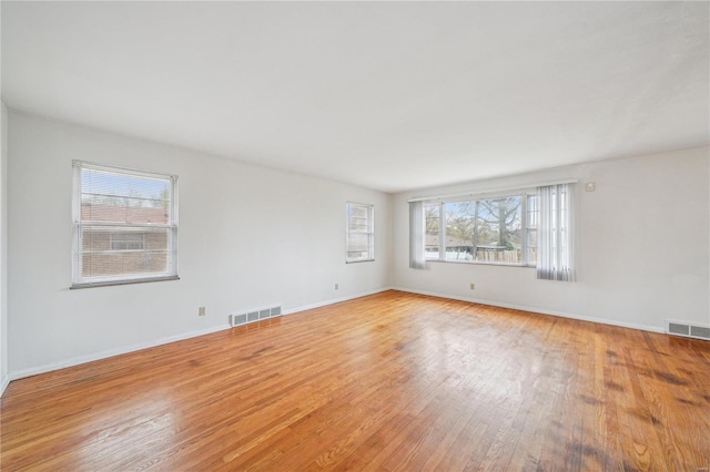 spare room with visible vents, baseboards, and light wood-type flooring