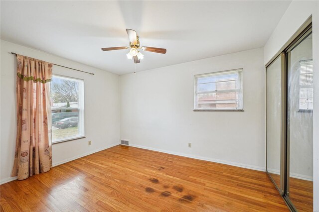 unfurnished bedroom with visible vents, baseboards, a closet, and light wood-style floors