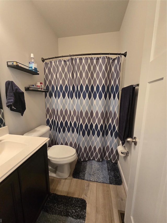 full bath featuring visible vents, curtained shower, toilet, vanity, and wood finished floors