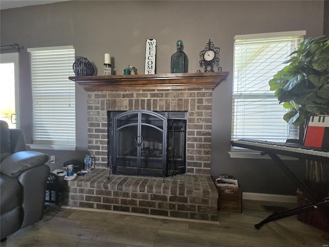 room details featuring a fireplace, baseboards, and wood finished floors