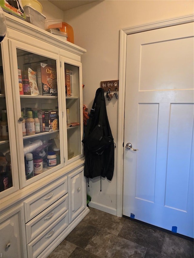 doorway with stone finish flooring and baseboards