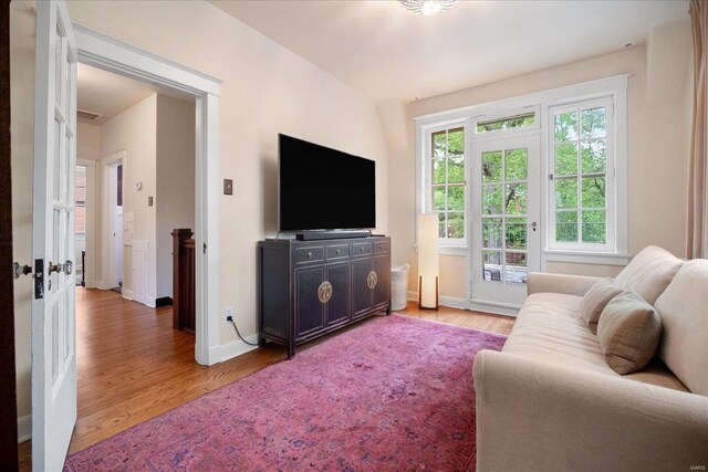 living area featuring baseboards and light wood-type flooring