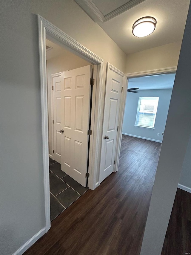 hall featuring dark wood-type flooring and baseboards