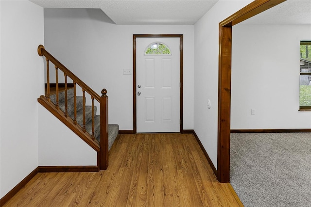 entrance foyer with baseboards, a wealth of natural light, stairway, and wood finished floors