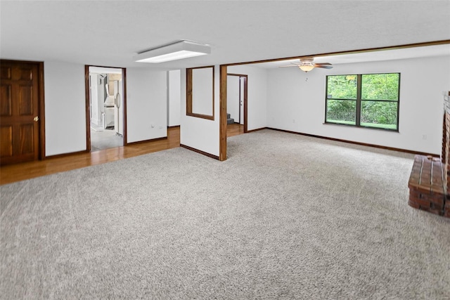 unfurnished living room with baseboards and carpet