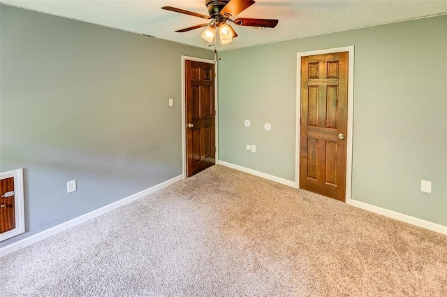 carpeted empty room featuring baseboards and a ceiling fan