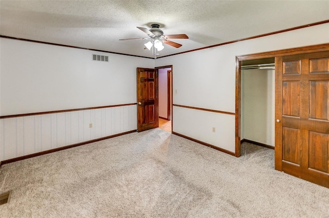 unfurnished bedroom featuring carpet flooring, a ceiling fan, baseboards, visible vents, and a closet