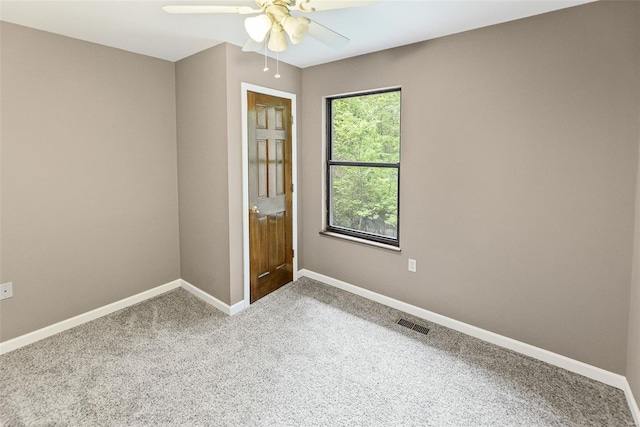spare room featuring baseboards, a ceiling fan, carpet flooring, and visible vents