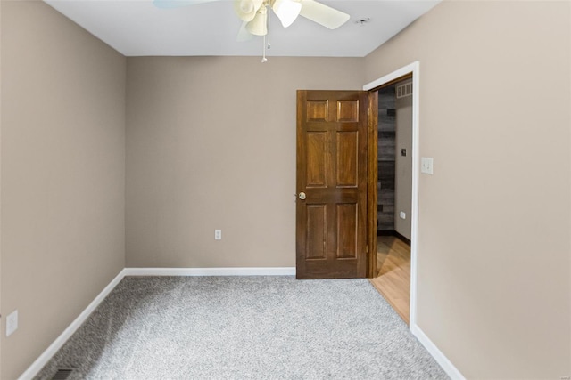 unfurnished room with ceiling fan, light colored carpet, and baseboards