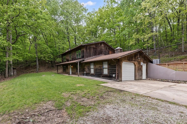 view of side of home with a garage, fence, concrete driveway, a lawn, and a porch
