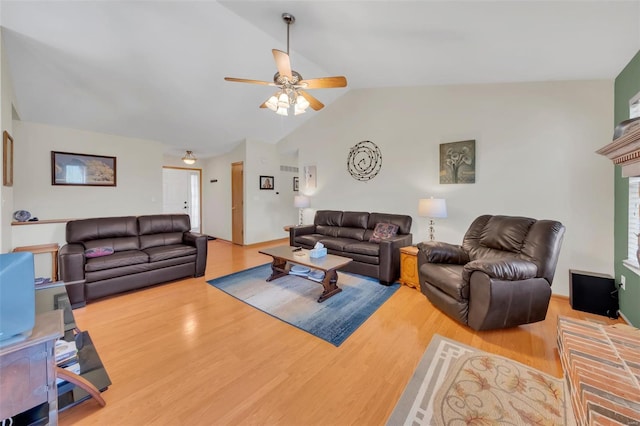 living room featuring wood finished floors, a ceiling fan, and vaulted ceiling