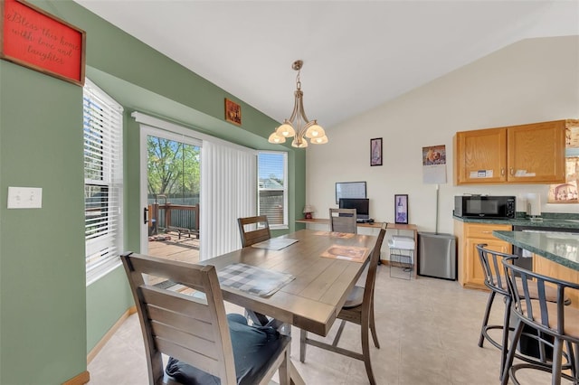 dining area featuring an inviting chandelier, baseboards, and lofted ceiling