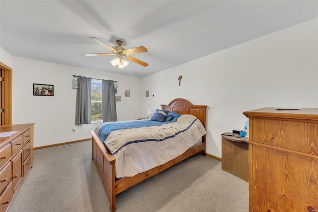 bedroom with light carpet, baseboards, and a ceiling fan