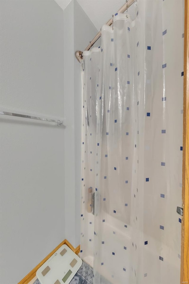 bathroom with baseboards and a shower with curtain
