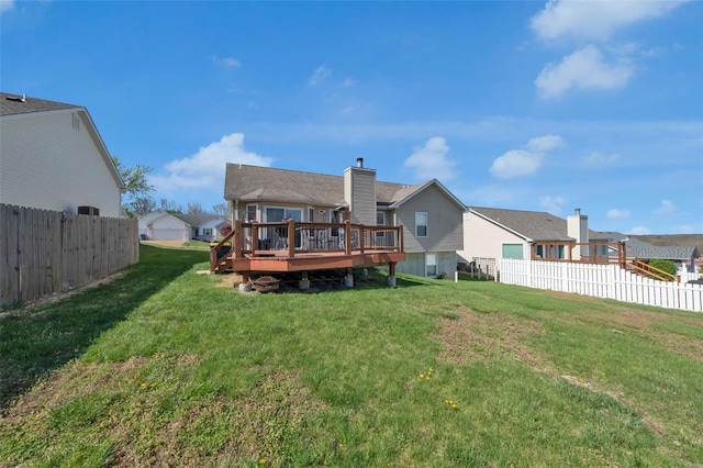 rear view of property with a fenced backyard, a deck, a residential view, and a lawn