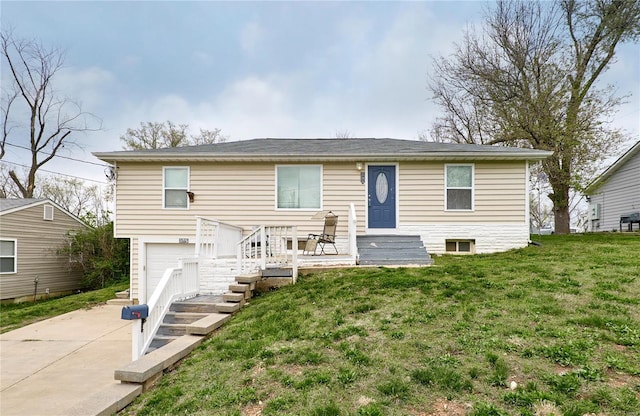 view of front of home with a garage, a front yard, and driveway