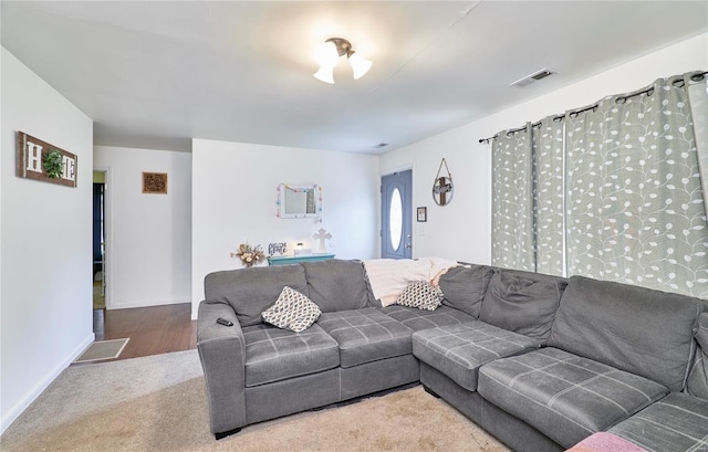 living room with visible vents, baseboards, and carpet floors