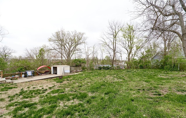 view of yard with an outdoor structure, a wooden deck, and fence