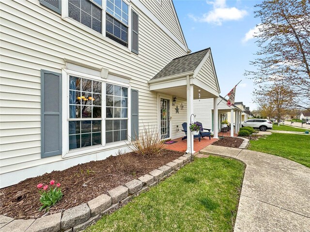 view of property exterior featuring a porch and a yard