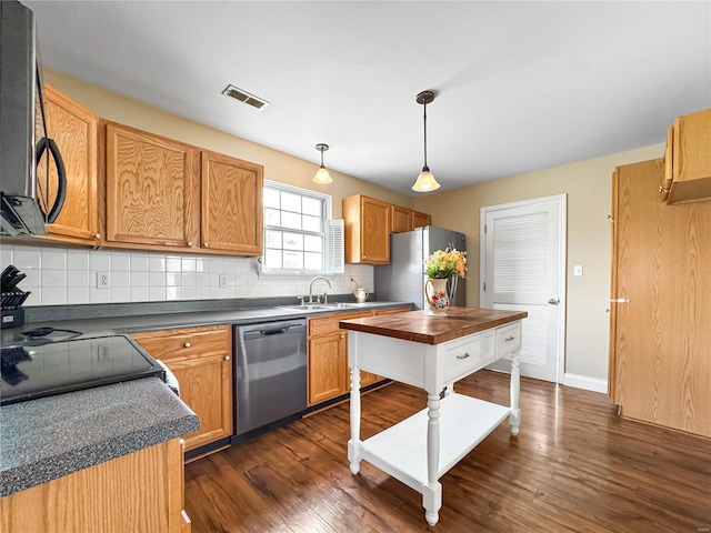 kitchen featuring backsplash, dark wood-style floors, visible vents, and stainless steel appliances