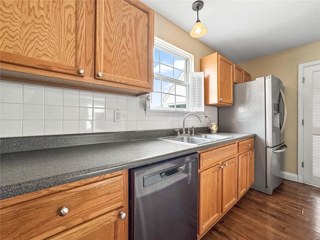 kitchen with backsplash, dark countertops, a sink, stainless steel appliances, and dark wood-style floors