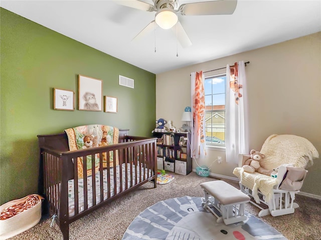 bedroom featuring a crib, baseboards, visible vents, and carpet floors