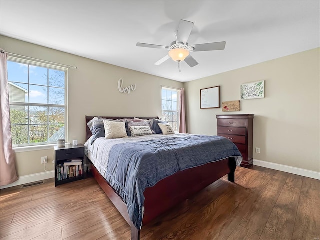 bedroom with visible vents, baseboards, a ceiling fan, and hardwood / wood-style flooring
