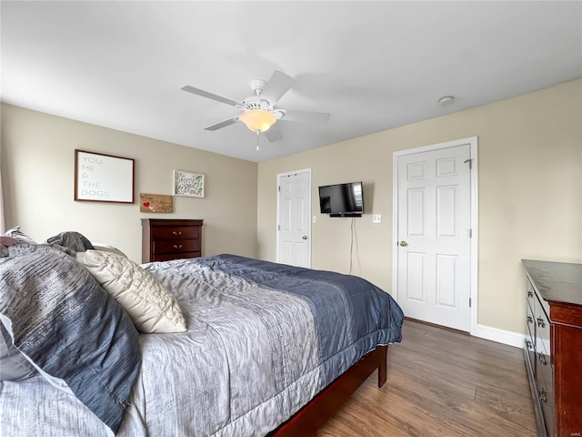 bedroom with dark wood-style flooring, baseboards, and a ceiling fan