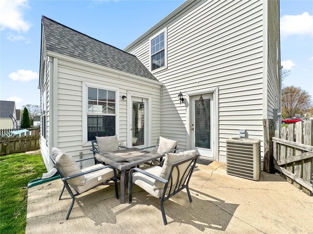view of patio featuring cooling unit, outdoor dining space, and fence