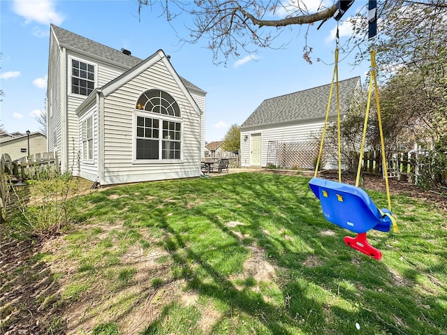 rear view of property with a yard, a patio area, and a playground