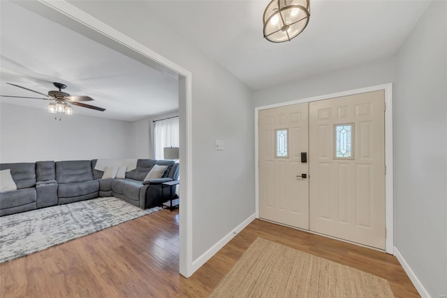 entryway featuring wood finished floors, ceiling fan, and baseboards