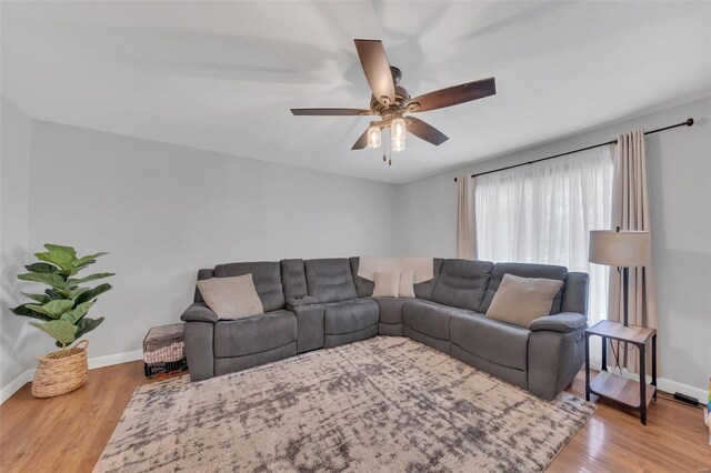 living room with ceiling fan, wood finished floors, and baseboards