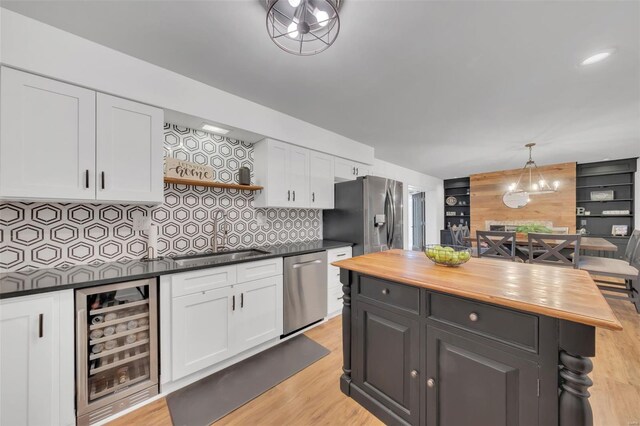 kitchen featuring white cabinets, appliances with stainless steel finishes, wine cooler, and wooden counters