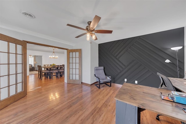 office featuring wood finished floors, ceiling fan with notable chandelier, and visible vents