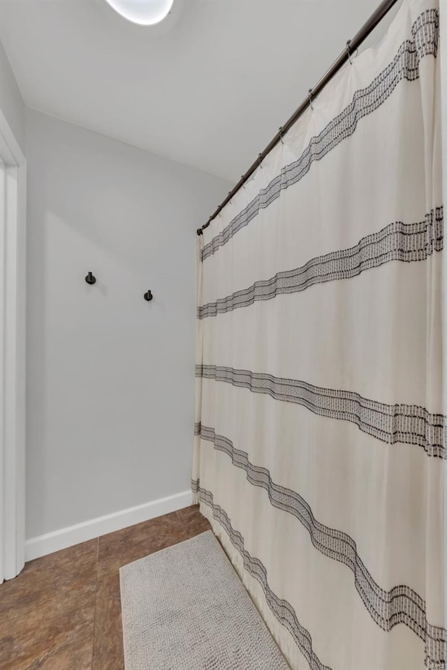 bathroom featuring baseboards and a shower with curtain